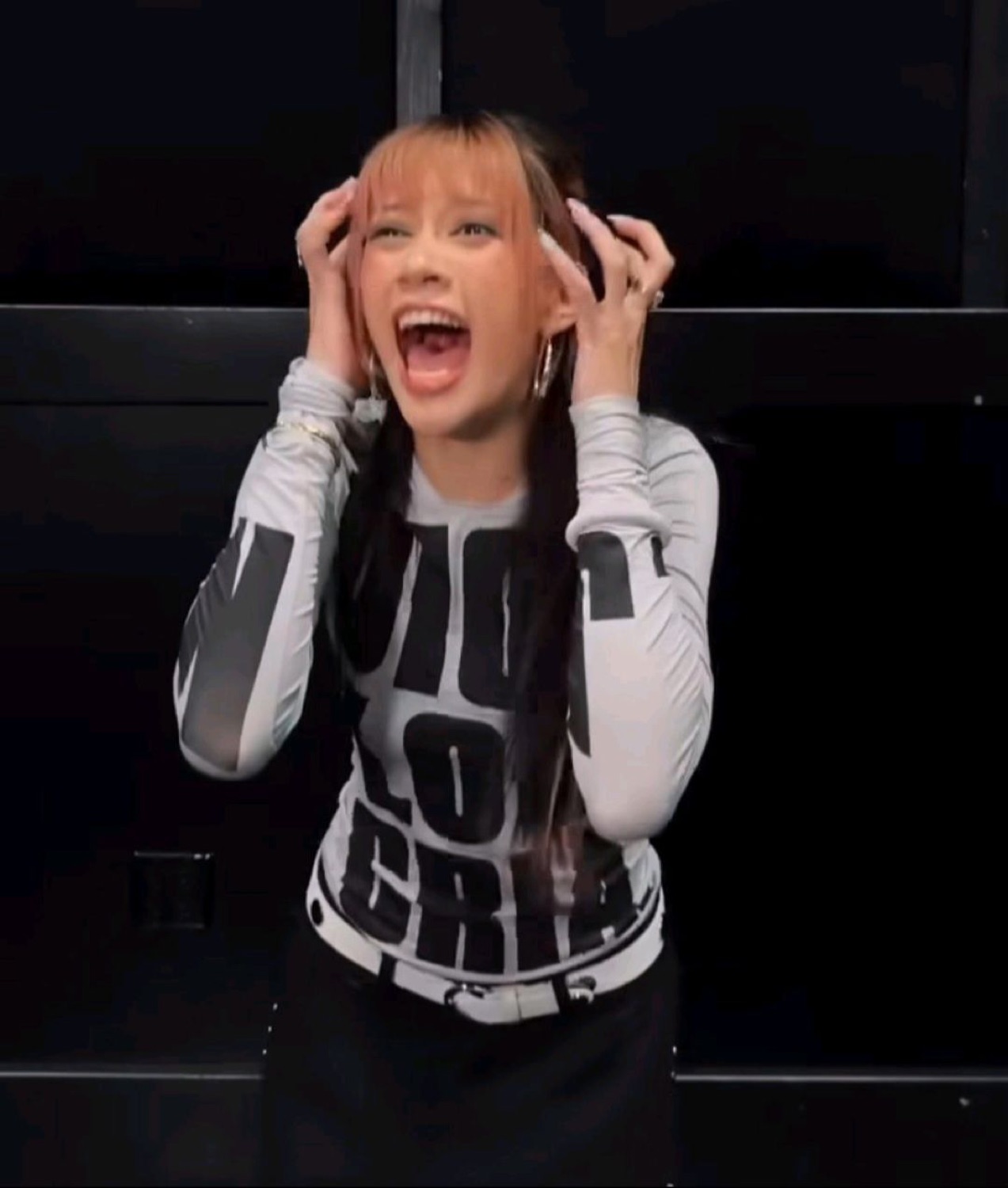 Girl gripping her head and screaming with excitement, mouth wide open