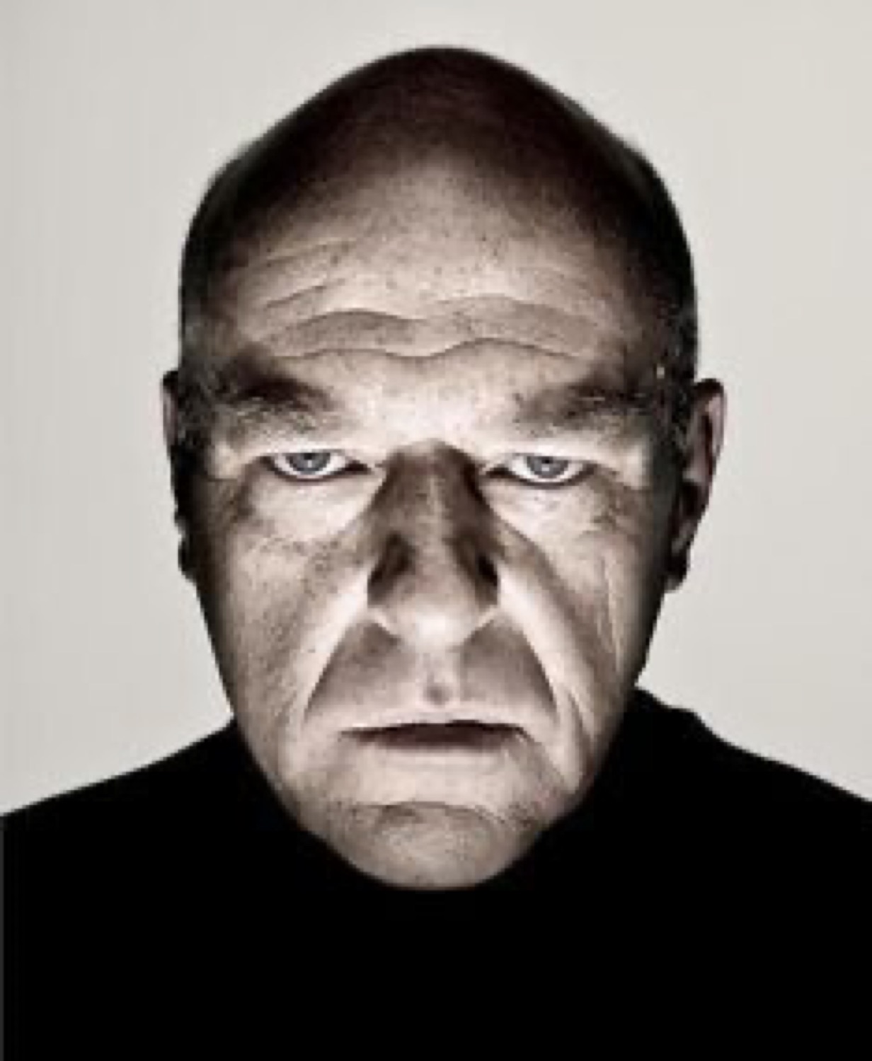 Bald man with deeply furrowed brows staring into your soul with pure contempt
