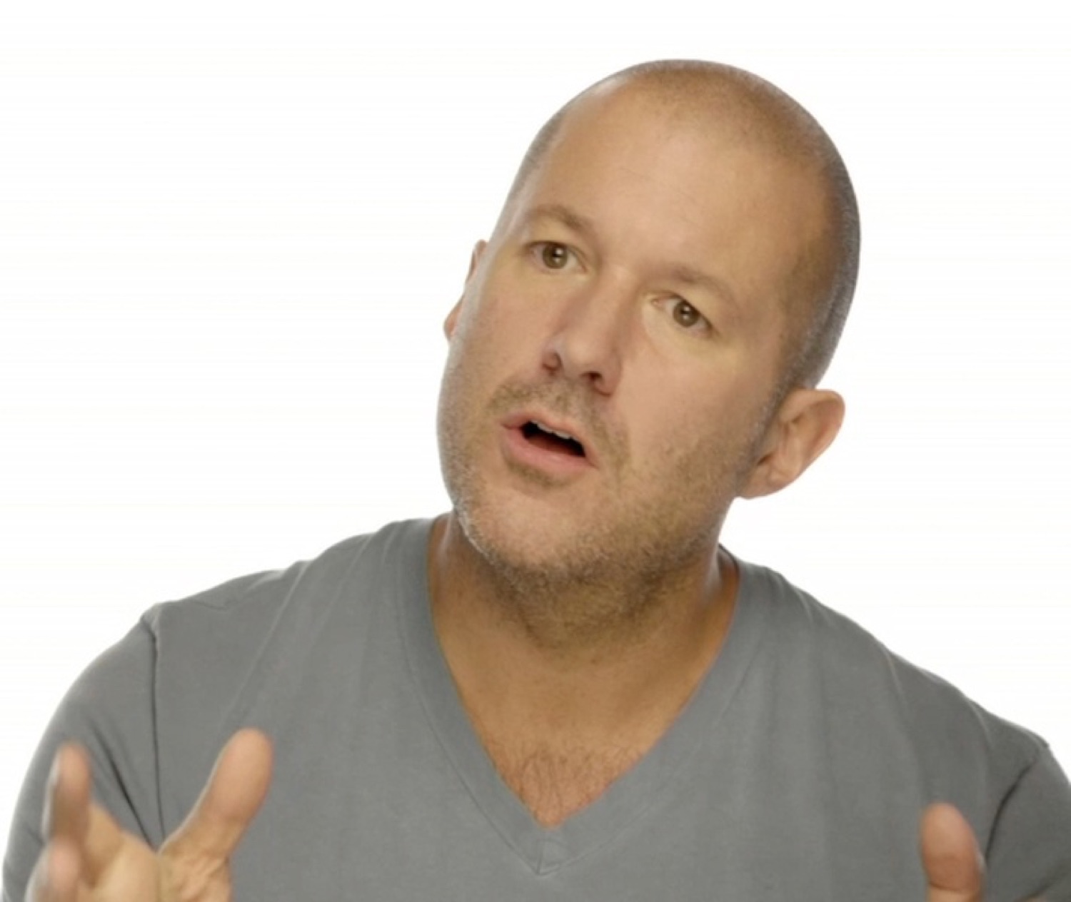 Bald man in a grey tee mid-sentence, gesturing with both hands as he earnestly explains