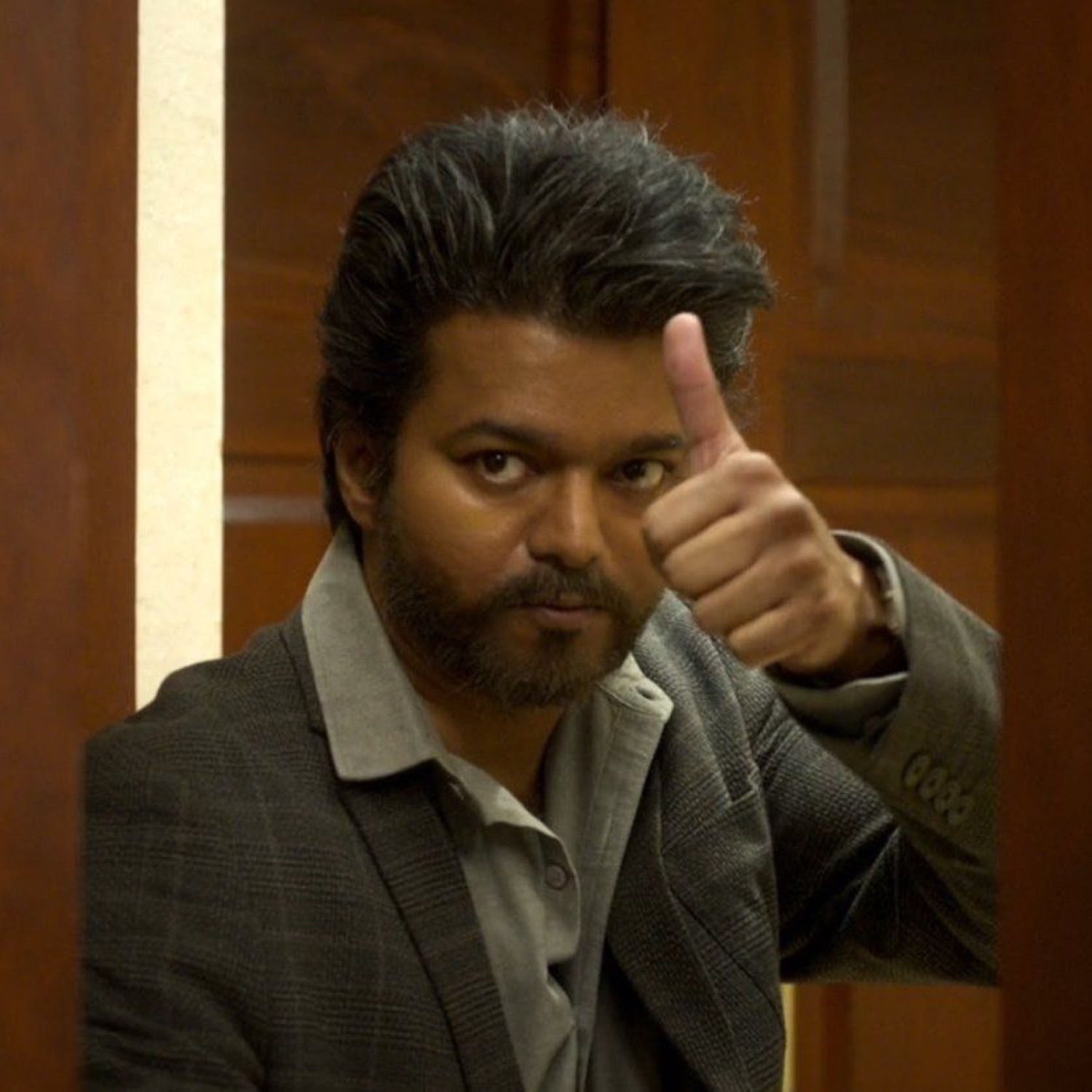 Bearded Vijay in a blazer giving a thumbs-up