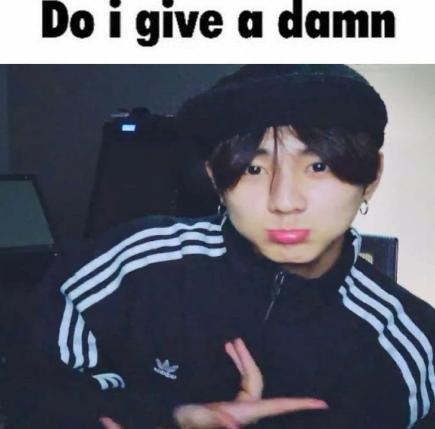 Young man in an Adidas jacket smirking coolly, captioned 'Do i give a damn'