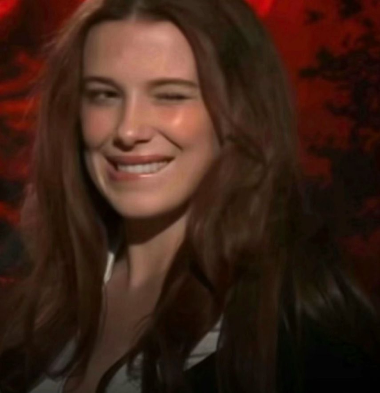 Woman glancing off to the side with a smile she's clearly trying to hold in