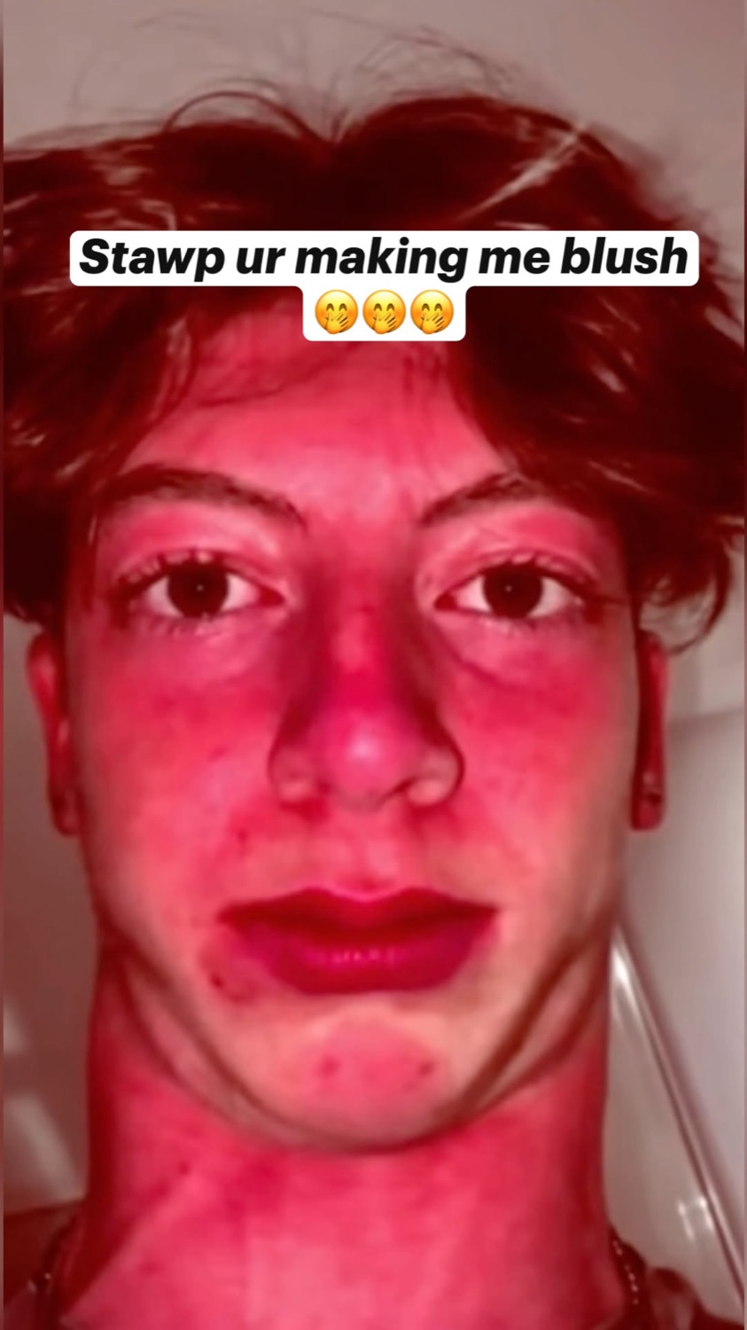 Young man's face flushed bright red under pink lighting with text 'Stawp ur making me blush'