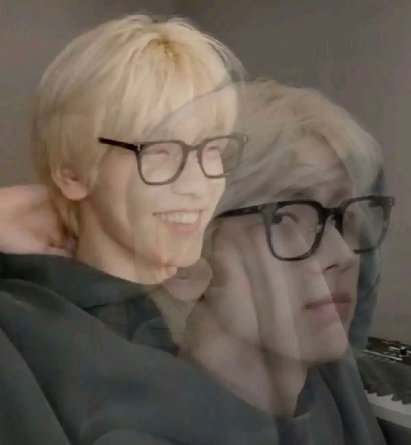 Blonde guy in glasses cross-faded between a big grin and a flat blank stare