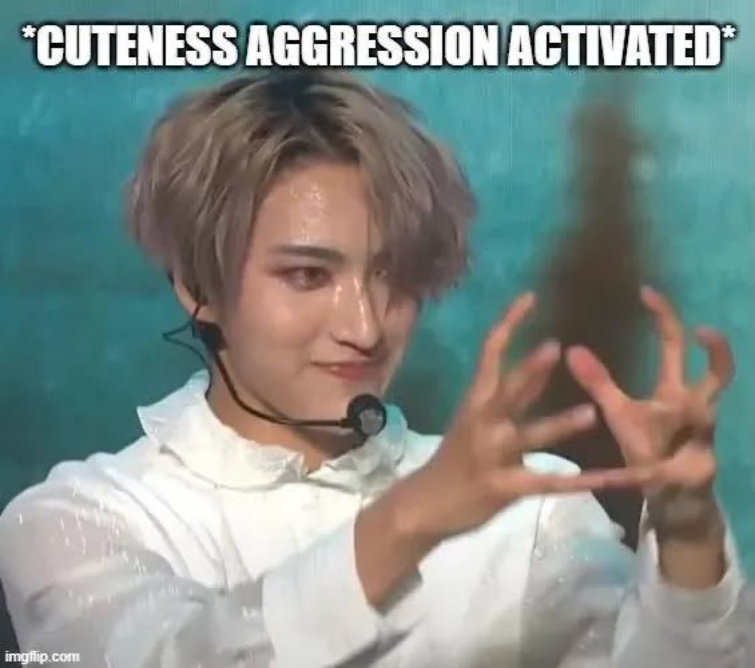 K-pop performer on stage with a menacing smile and claw hand, captioned '*CUTENESS AGGRESSION ACTIVATED*'
