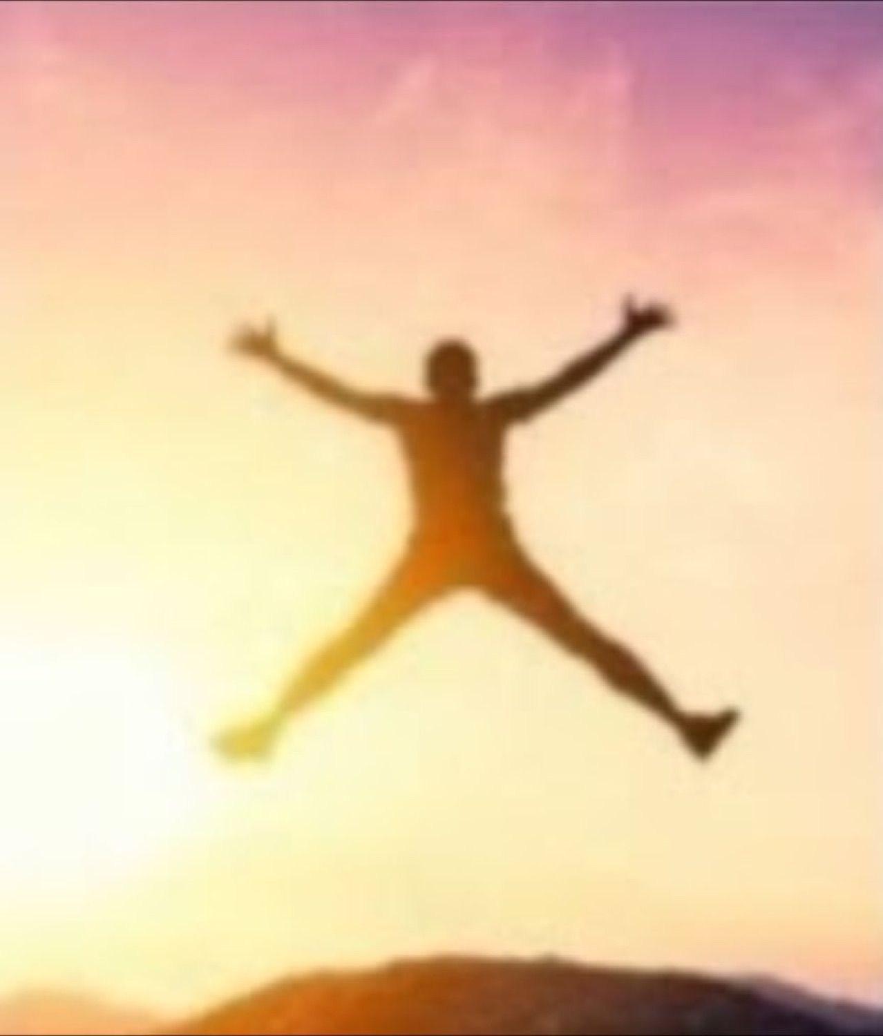 Silhouette of a person leaping arms-and-legs-out against a pink sunset sky