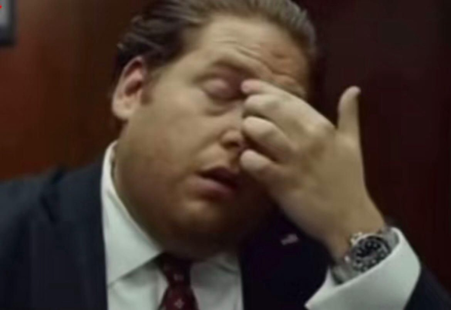 Jonah Hill pinching the bridge of his nose in exhaustion