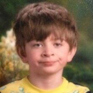 Young kid with a sly smirk giving serious side-eye energy