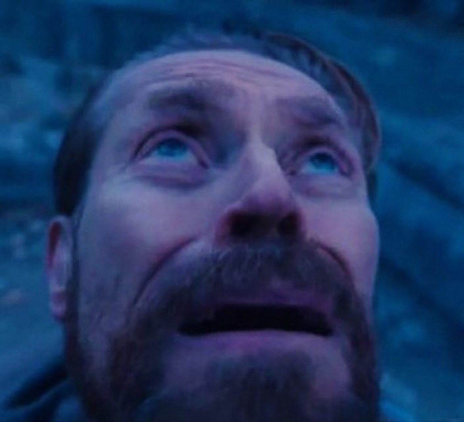Willem Dafoe looking up teary-eyed in awe