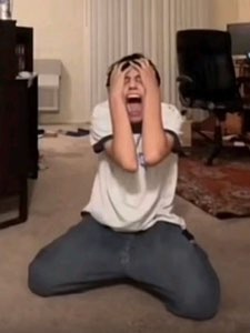 Person on their knees on the floor, screaming into their hands in full meltdown mode