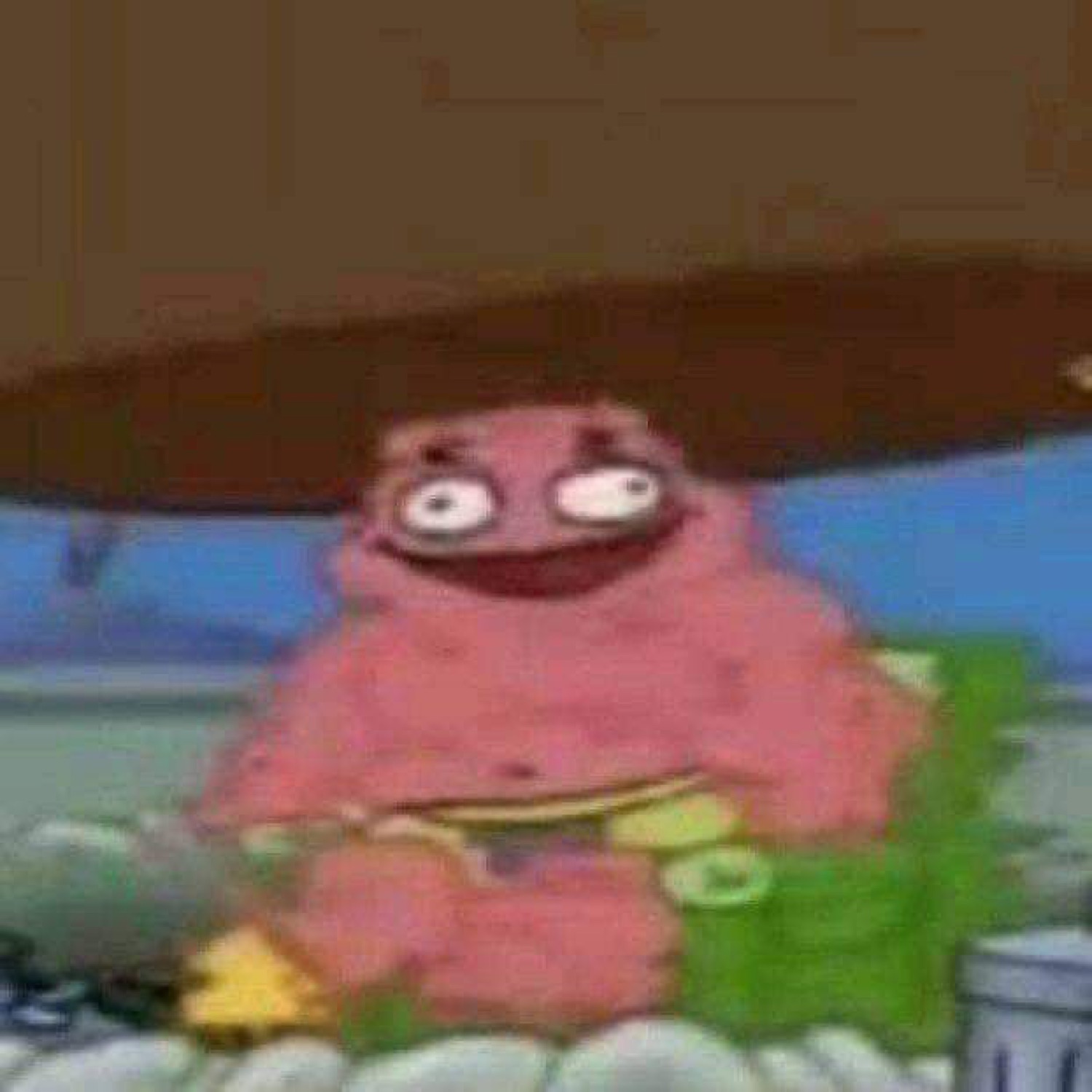 Patrick Star sitting in a garbage pile with bulging eyes and a manic grin