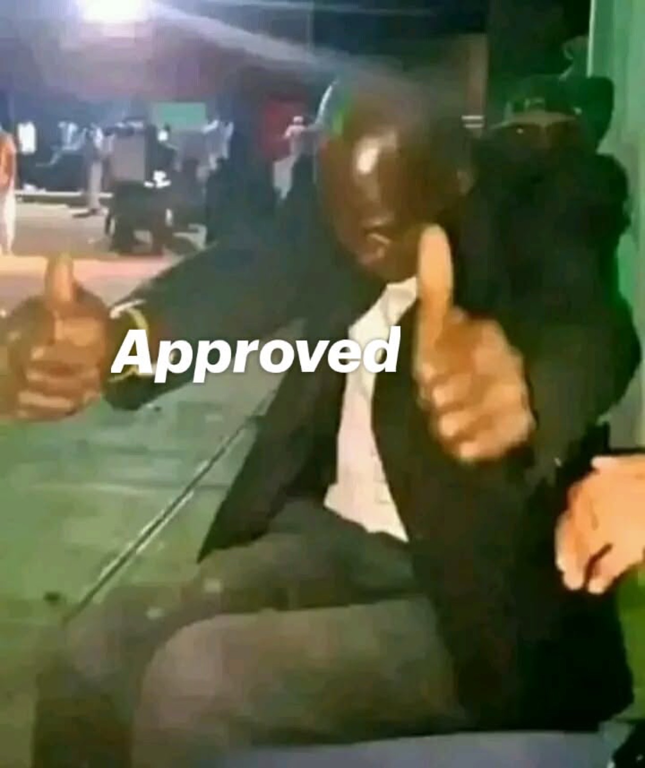 Man giving two thumbs up at night: 'Approved'