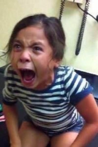 Little girl in a striped shirt screaming with mouth wide open in pure outrage