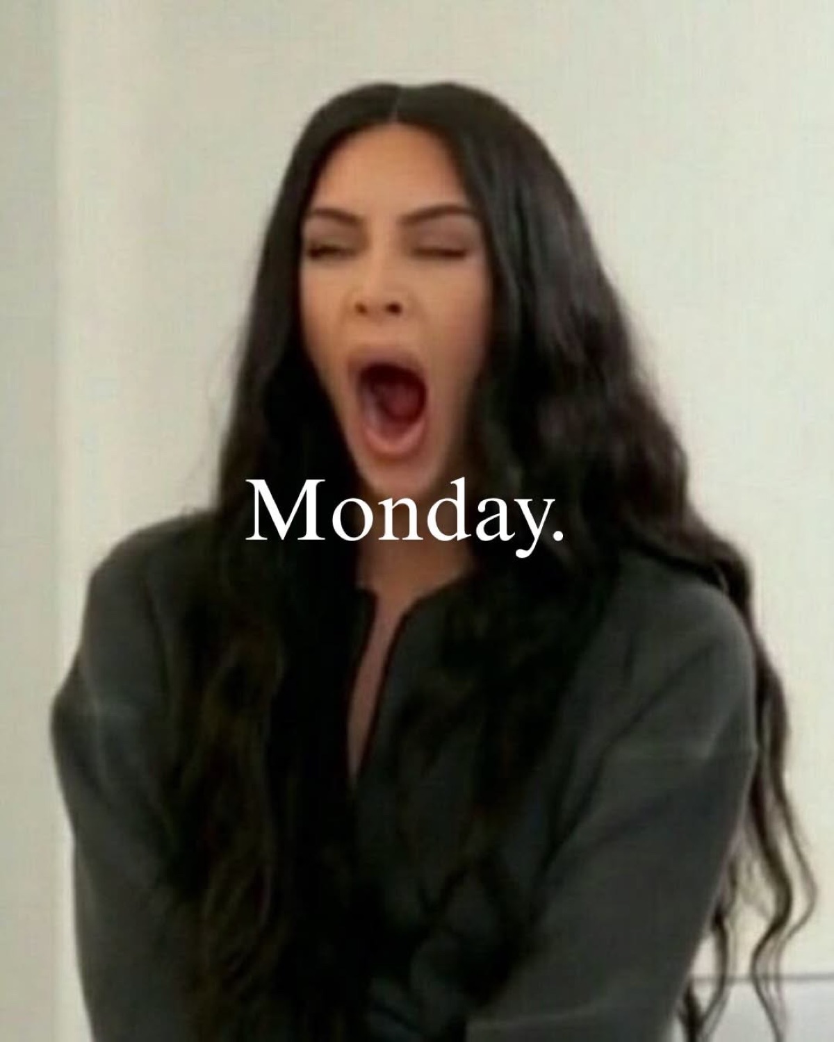 Kim Kardashian mid-yawn with eyes squeezed shut, captioned 'Monday.'