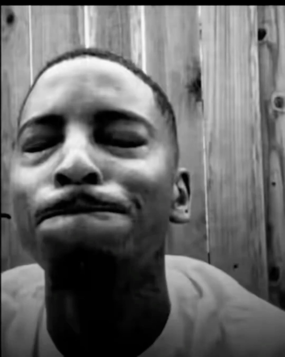 Man squinting with puckered lips in black and white