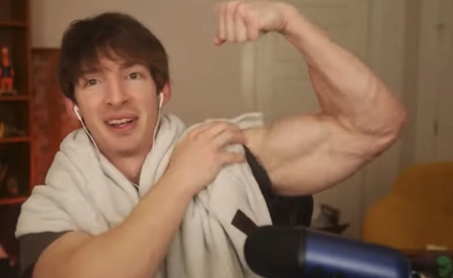 Guy grinning while flexing a massive bicep