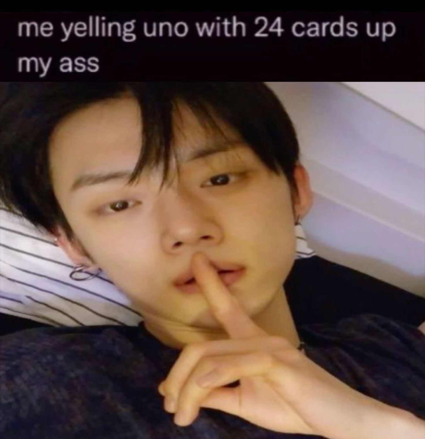 Guy lying in bed shushing the camera under 'me yelling uno with 24 cards up my ass'