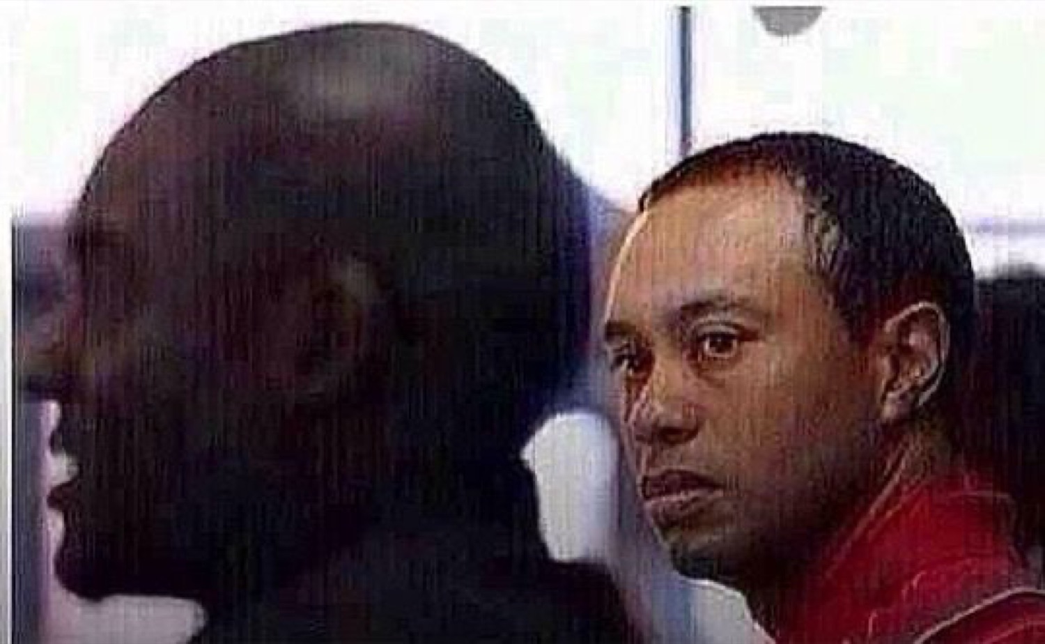 Tiger Woods giving a stunned sideways look at the man next to him