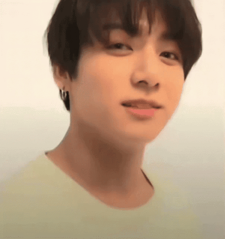 Jungkook from BTS looking at the camera then turning away