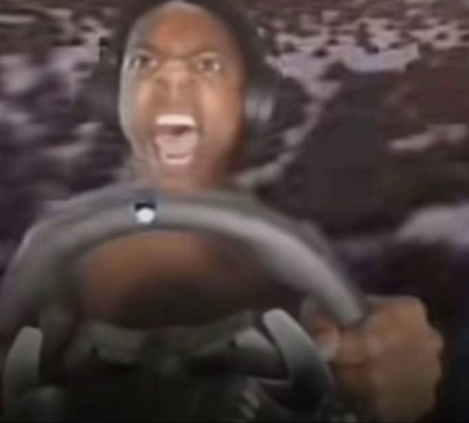 Kid on a racing game rig screaming with wild intensity behind the wheel