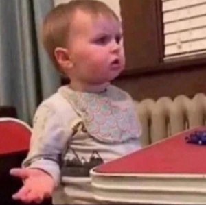 Toddler gesturing with an open hand and a confused, offended expression