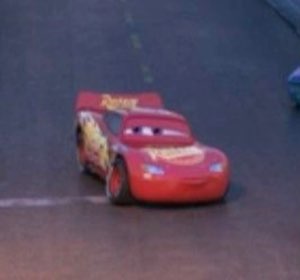 Tiny Lightning McQueen driving away down the road