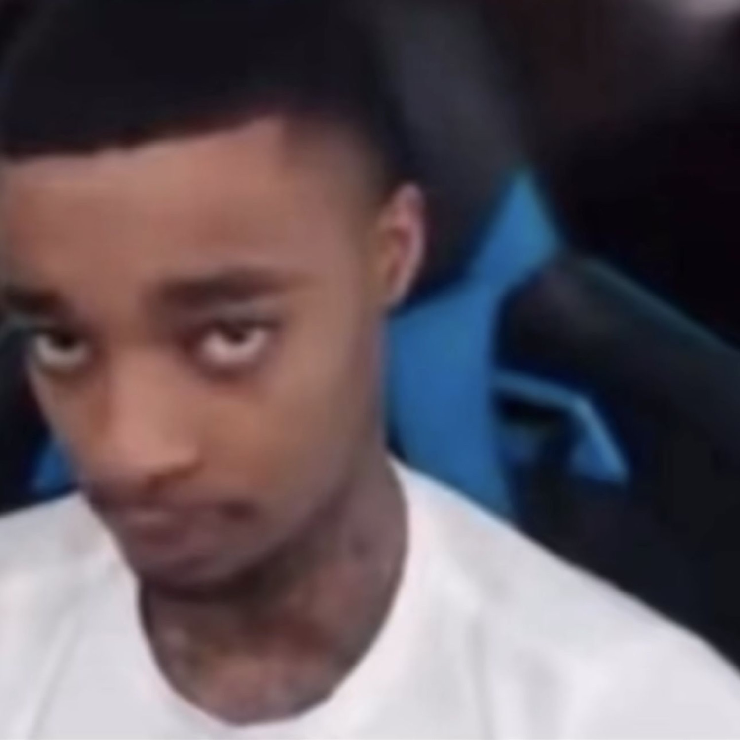 Young man in a gaming chair cutting his eyes to the side with maximum suspicion