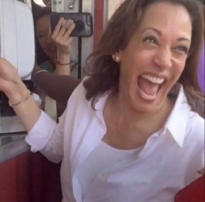 Kamala Harris laughing with full energy, arms wide, completely delighted