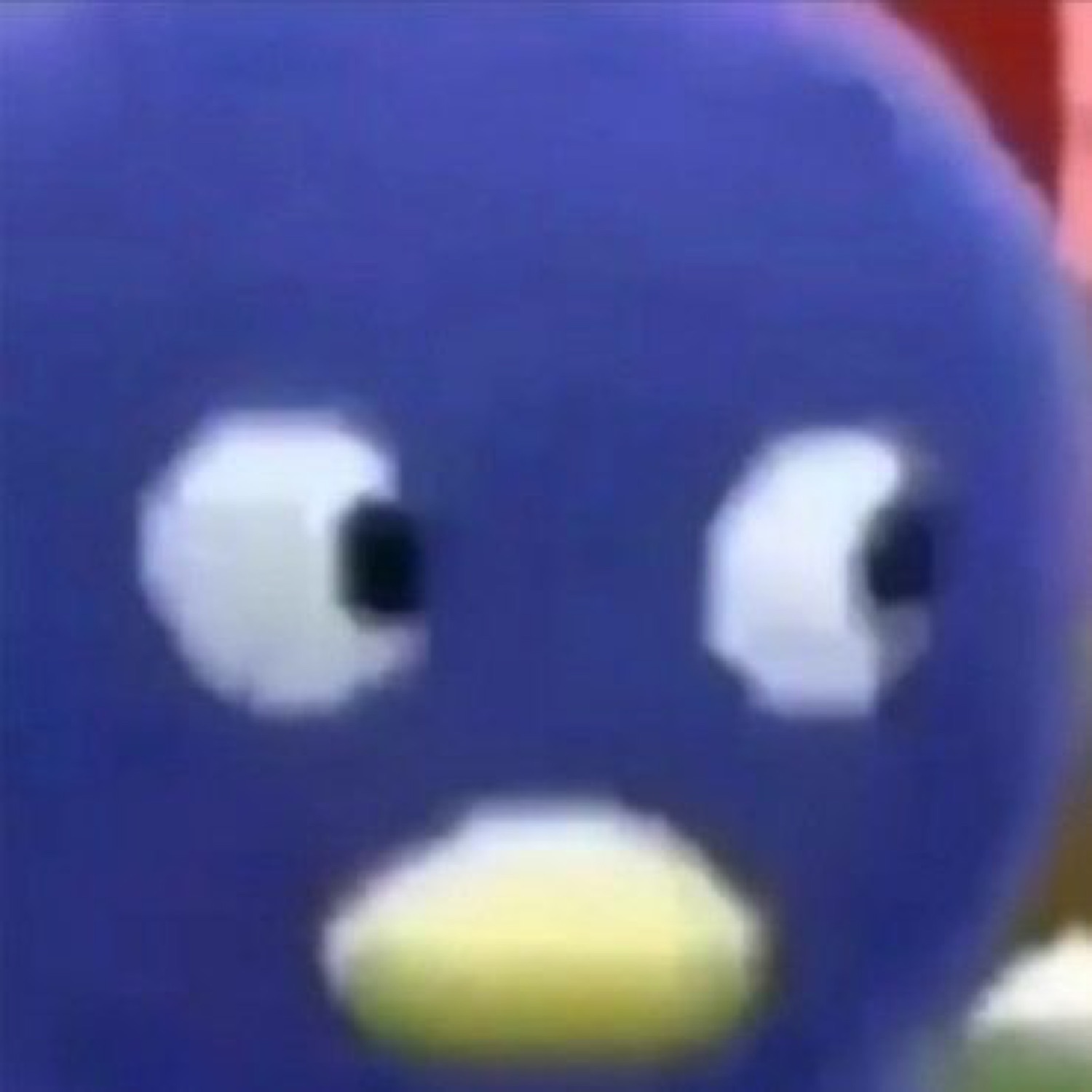 Blue penguin-like cartoon character with a wide-eyed blank stare, close-up face