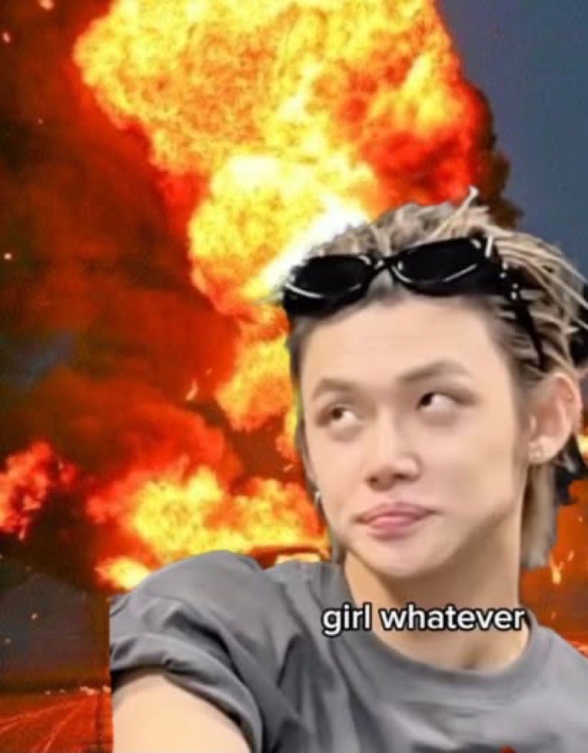 Person rolling their eyes in front of a fiery explosion captioned 'girl whatever'