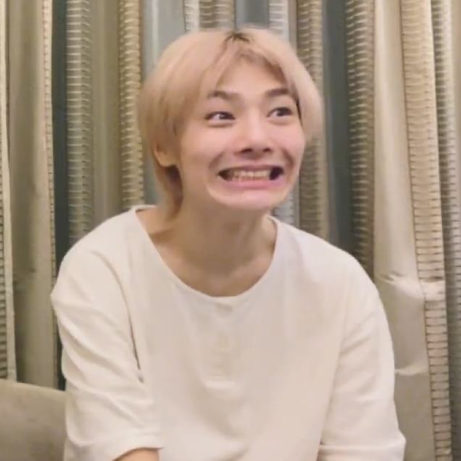 Person with a wide clenched-teeth grimace giving a strained, awkward smile