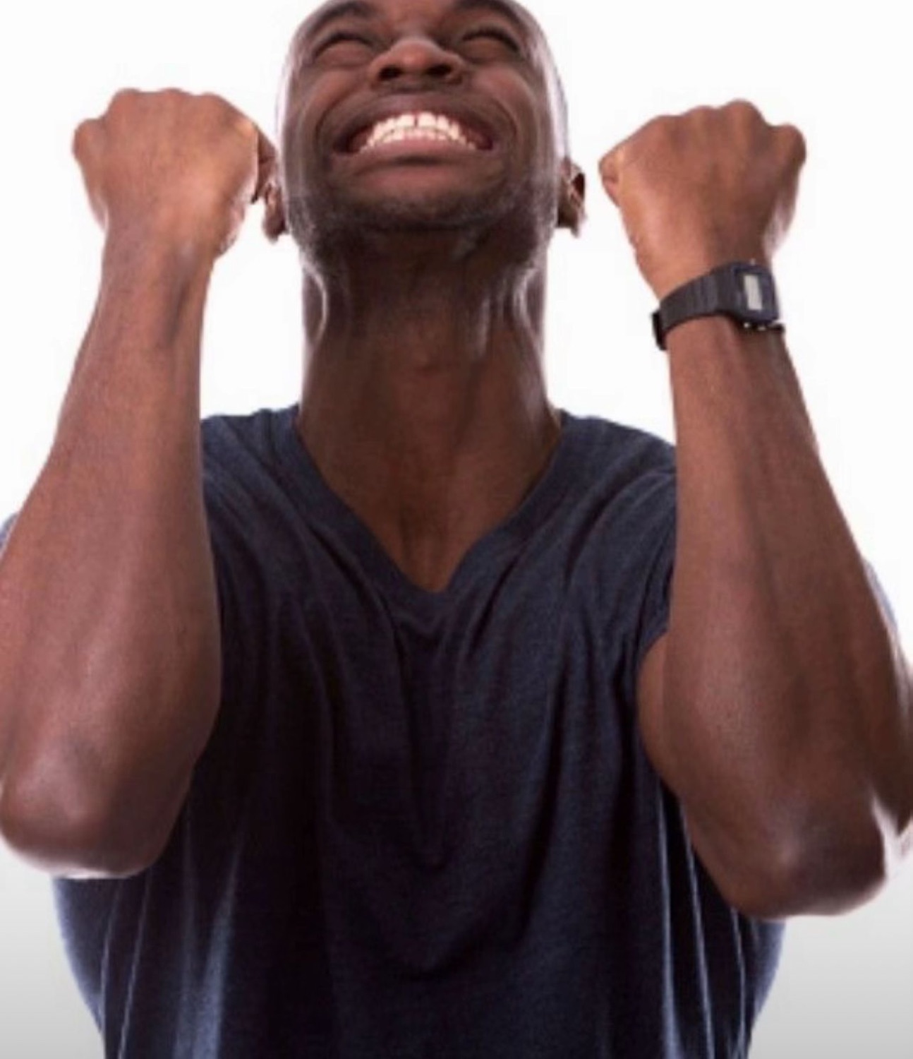Man in dark t-shirt pumping both fists in the air with eyes closed, ecstatic