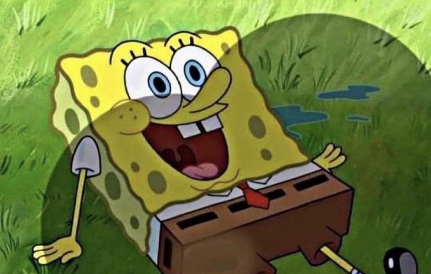 SpongeBob sprawled on the grass with a shovel, grinning ear to ear