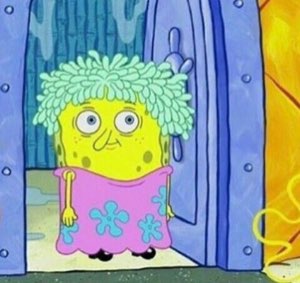 SpongeBob in a mop wig and pink dress standing in the doorway looking rough