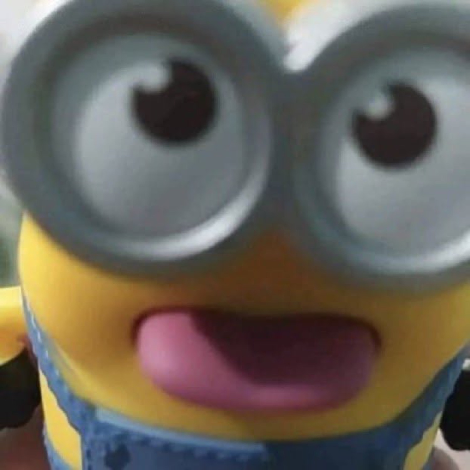 Blurry close-up of a Minion with goggles and its tongue flopping out