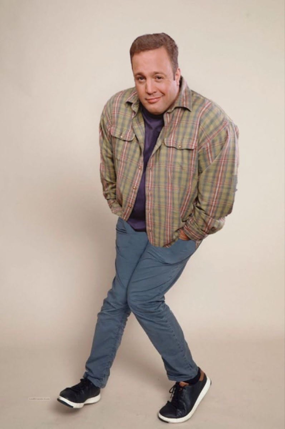 Kevin James standing hands-in-pockets with a smirk and a slight lean