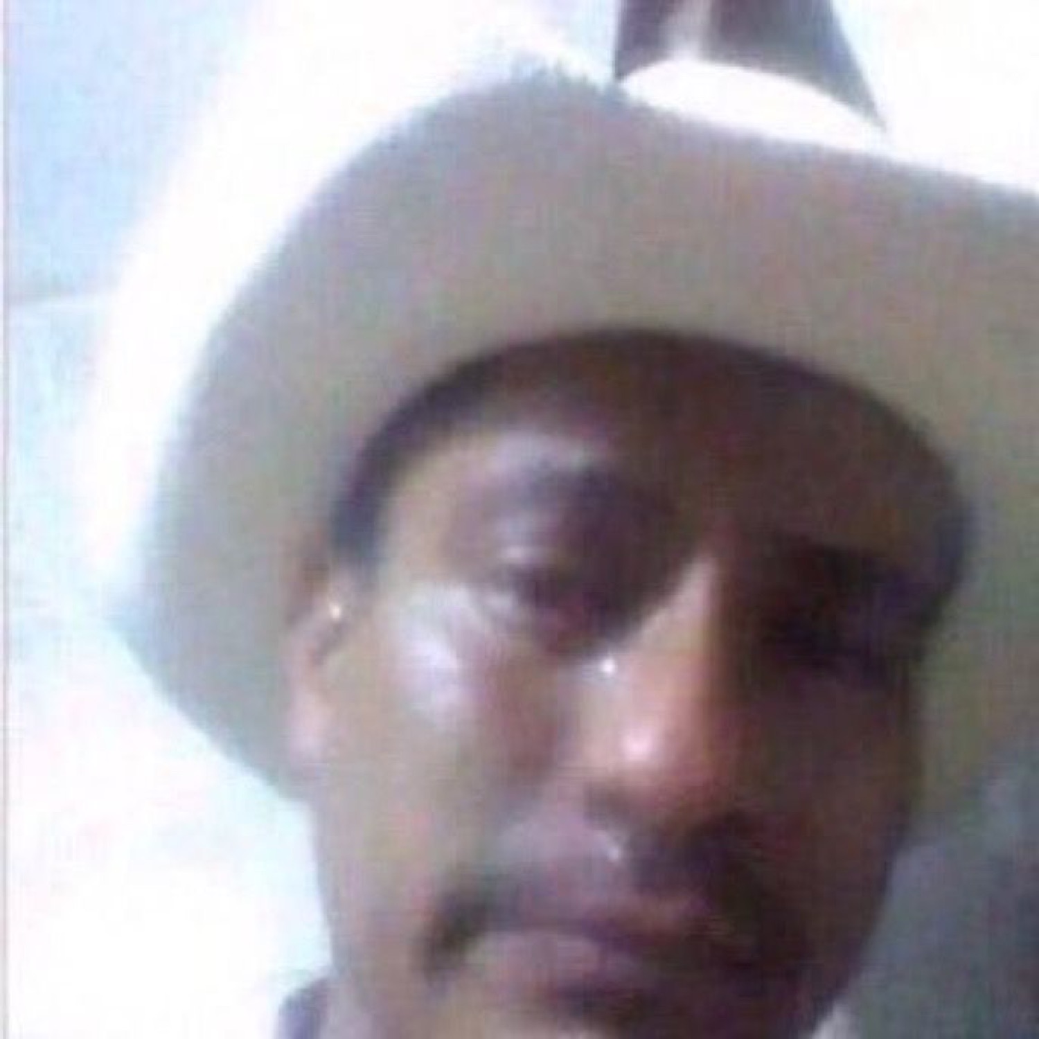 Man in a white cowboy hat with tears streaming down a completely deadpan face