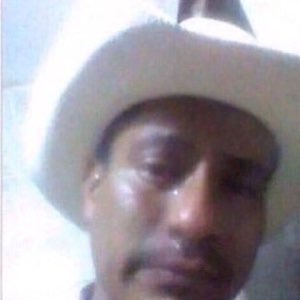 Man in a white cowboy hat with tears streaming down a completely deadpan face
