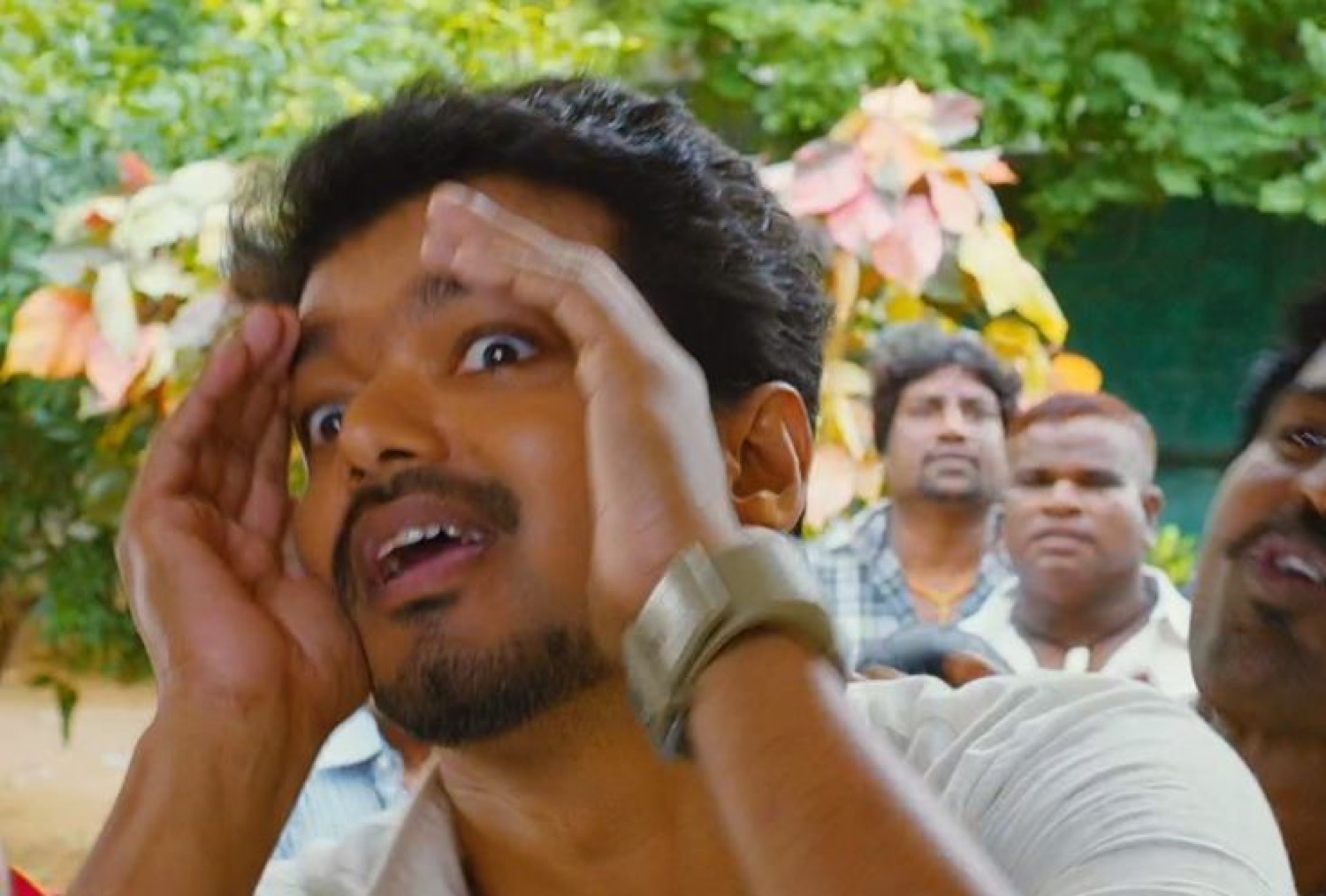 Vijay shading his eyes and squinting into the distance