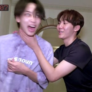 Two Korean guys cracking up — one completely losing it while the other grabs his neck