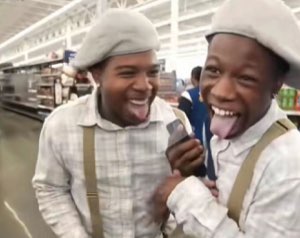 Two guys in matching berets cracking up with their tongues out in a supermarket aisle