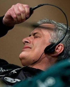 Grey-haired coach wincing as a headset is yanked off his head