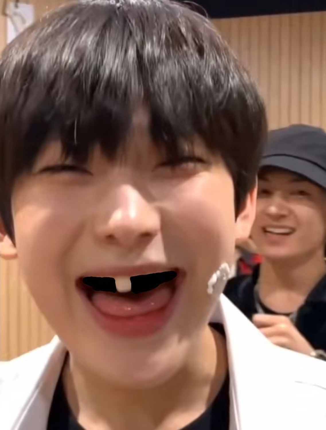 Young man laughing hard with a black gap edited over his front teeth