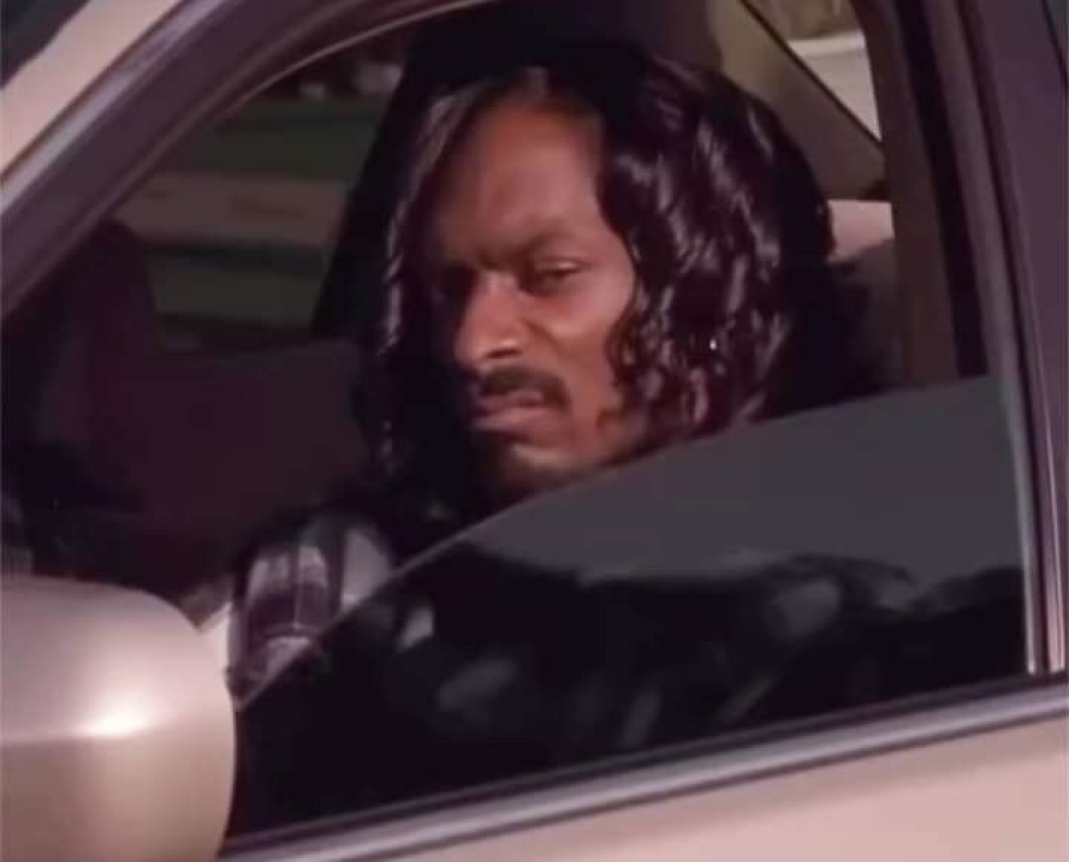 Snoop Dogg driving with a focused look
