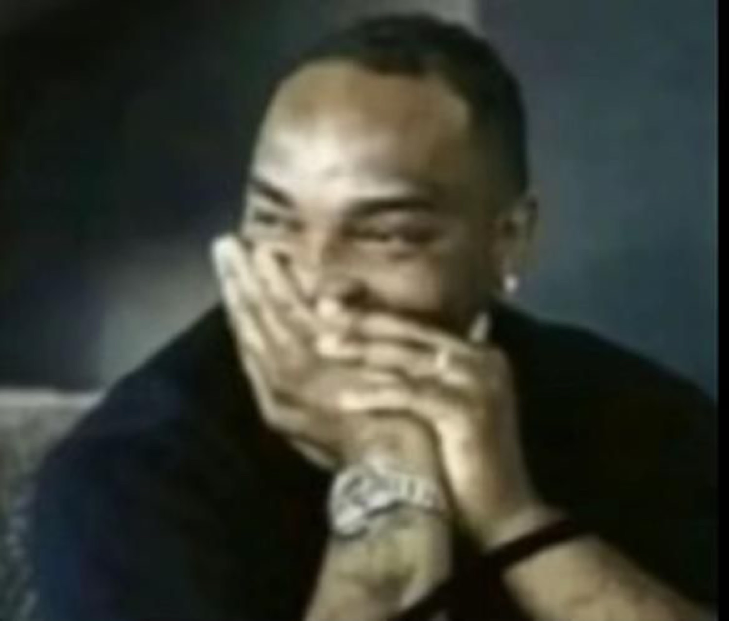 Man hiding a laugh behind both hands, cracking up but trying to hold it in