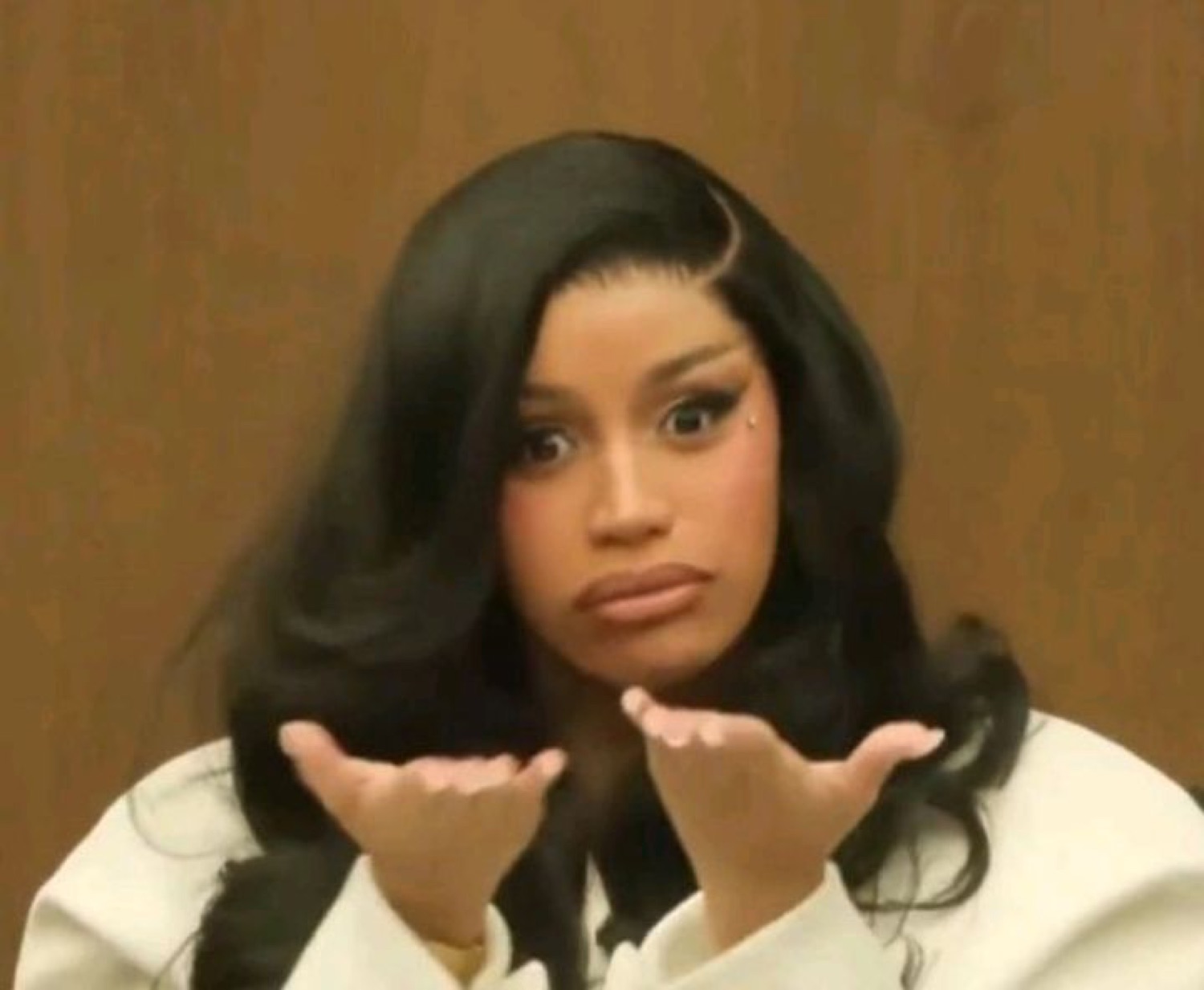 Cardi B with palms up in a 'what did you expect' shrug