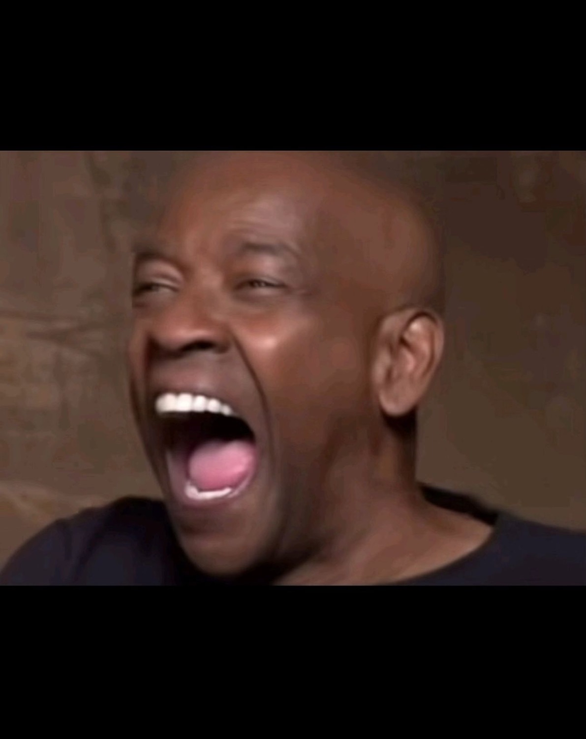 Man tilting his head back mid-laugh with his mouth wide open in delight