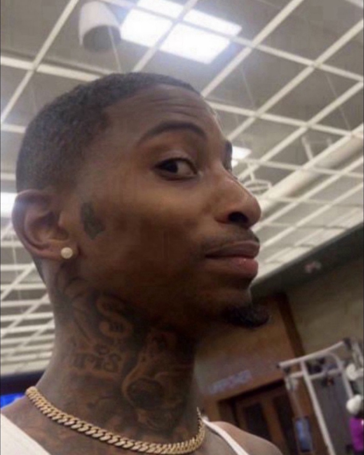 Tattooed guy with a gold chain looking at you like he already knows what you did