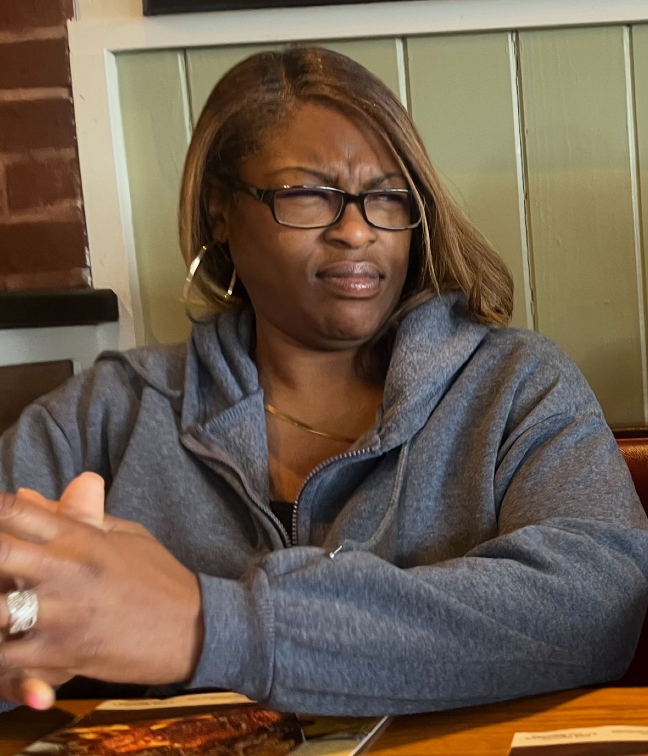 Woman in a booth with glasses giving a deeply disgusted, unimpressed scowl