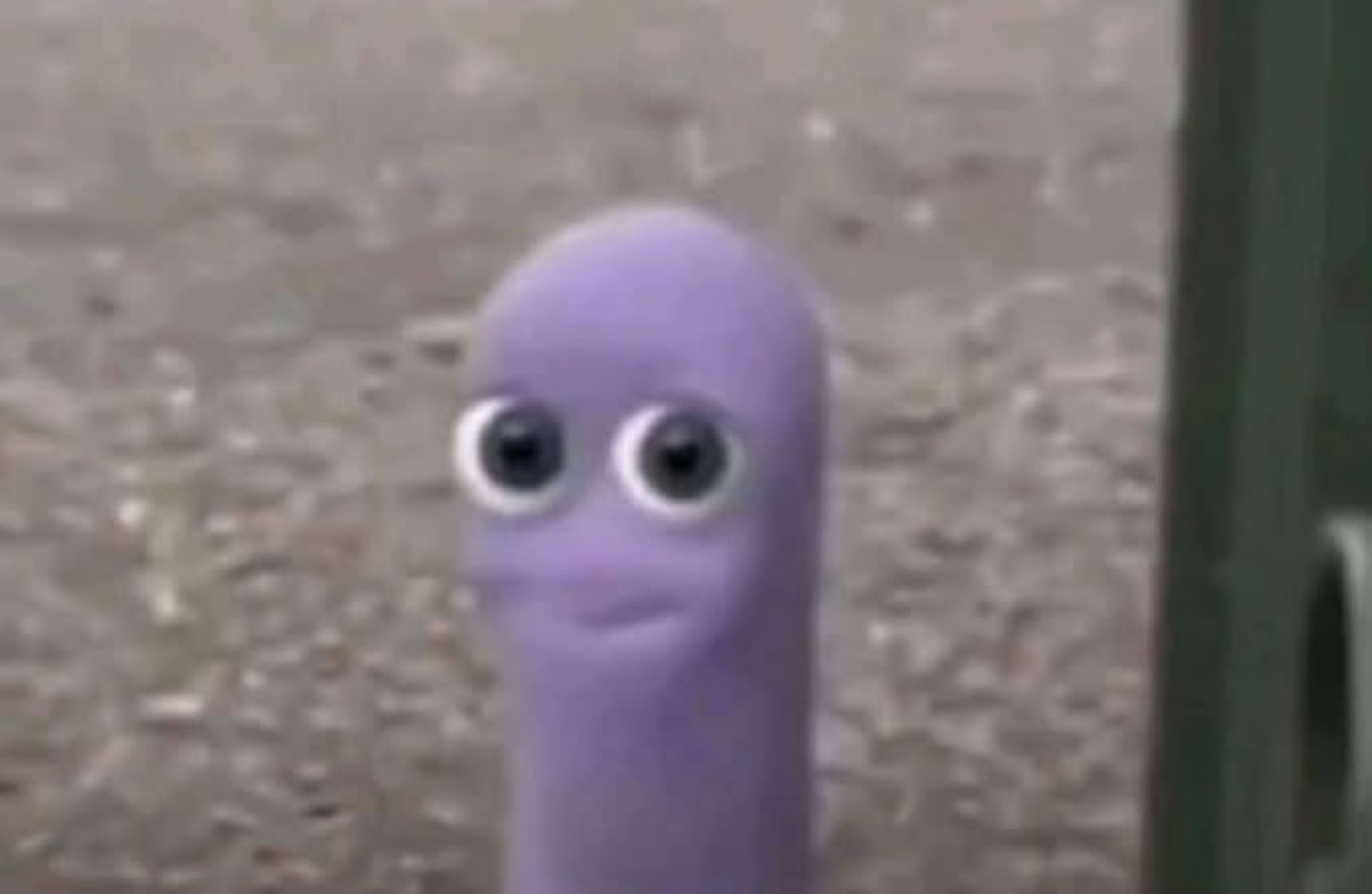 Little purple blob creature with googly eyes staring blankly at the camera